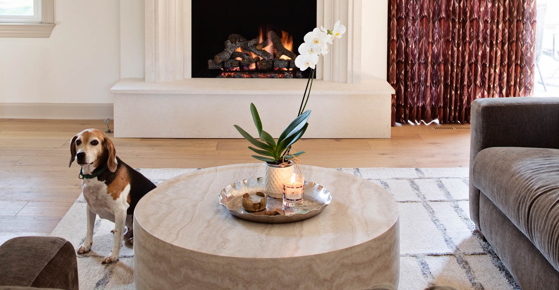Warm, modern living room with Killarney Kingfisher flooring, textured rug, and structural fireplace.