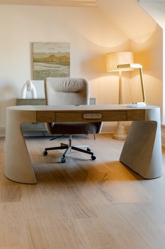 Modern workspace with architectural desk and light wood floors creating a calm, refined atmosphere.