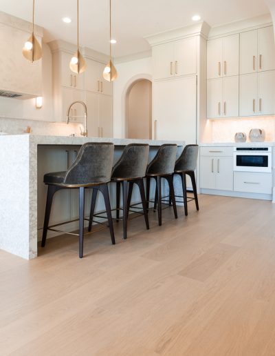 Bright and sophisticated kitchen with pale oak flooring and gold-accented cabinetry.