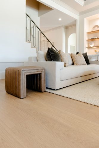 Sophisticated living space featuring pale oak flooring, layered neutral textiles, and sculptural contemporary seating.