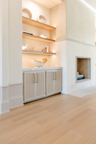 Bright, inviting living room with warm wood floors, soft beige furnishings, and minimalist decor creating a serene feel.