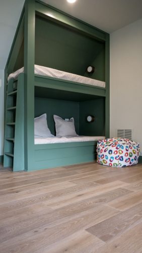 Built-in bunk beds in playful green with european white oak flooring underfoot