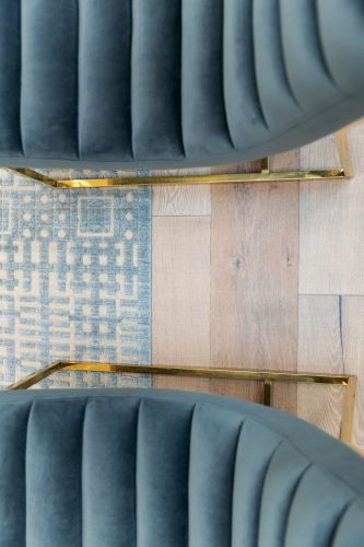 Teal chairs with coordinating rug and european white oak flooring.