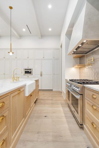 Vintage Loft Bowery featured in Houston kitchen with coordinating wood cabinets and gold hardware.