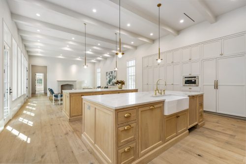 Neutral tone kitchen with white oak flooring and matching cabinets.