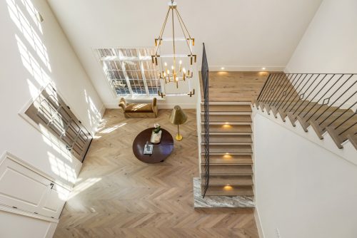 Grand stair case with European White Oak flooring off of bright, light-filled entryway.