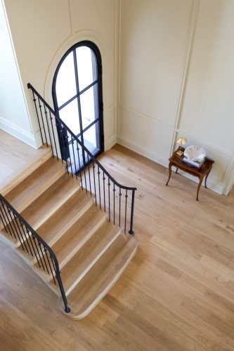 Interior foyer with hardwood floors and iron railing detail in Murphy Custom Home build.