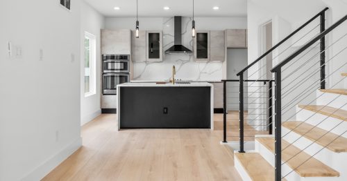 Minimalist kitchen with clean lines and light natural-tone wood composite floors