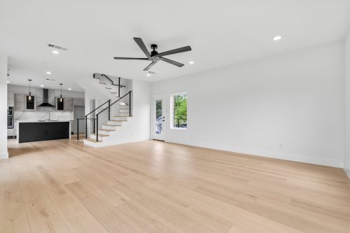 Bright open-concept living area with contemporary fireplace and natural tone composite flooring
