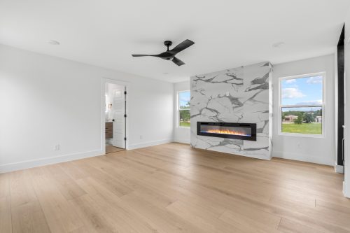 Minimalist lounge room with sleek fireplace and light oak-look composite flooring