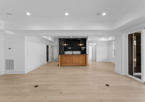 Large finished basement with bar area, featuring light european white oak flooring.