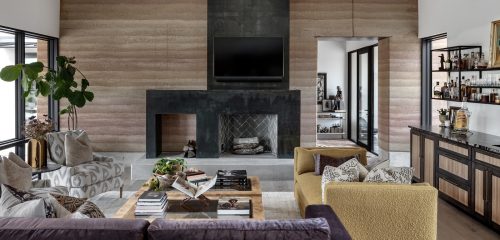 Living room with wide windows, earthy wood flooring, and layered textures inspired by the Texas Hill Country landscape