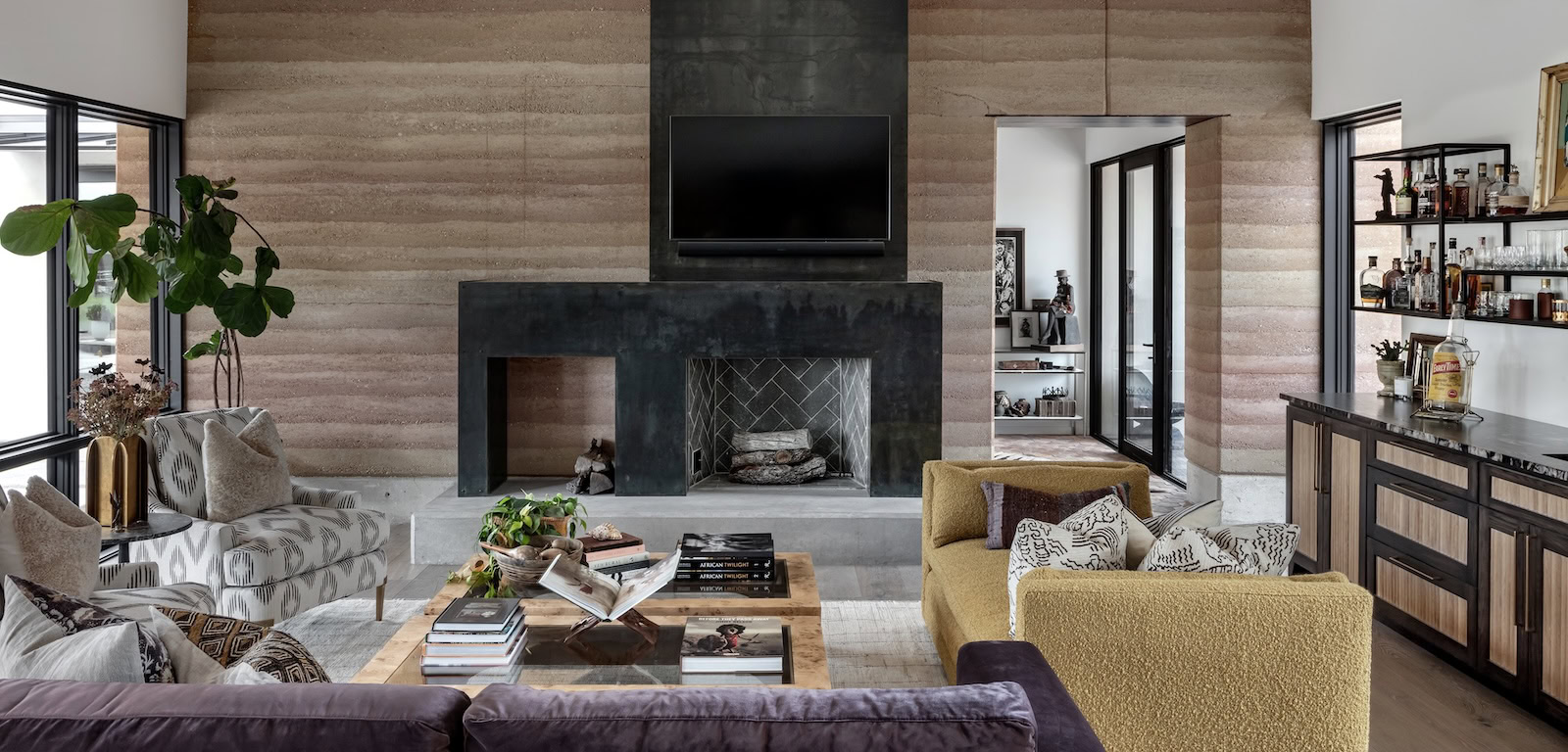 Living room with wide windows, earthy wood flooring, and layered textures inspired by the Texas Hill Country landscape