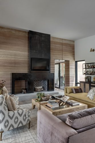 Modern, earthy living room with textured finishes, wood flooring, and soft natural light creating a grounded, organic feel