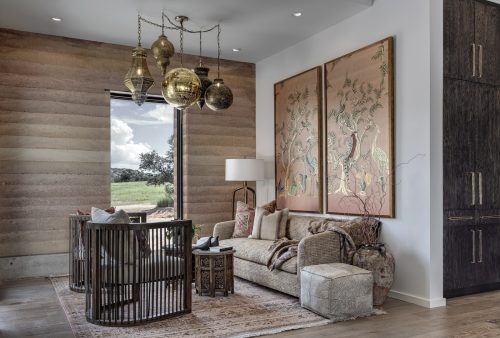 Intimate lounge space with natural wood floors and earthy tones, reflecting a relaxed, Hill Country–inspired design