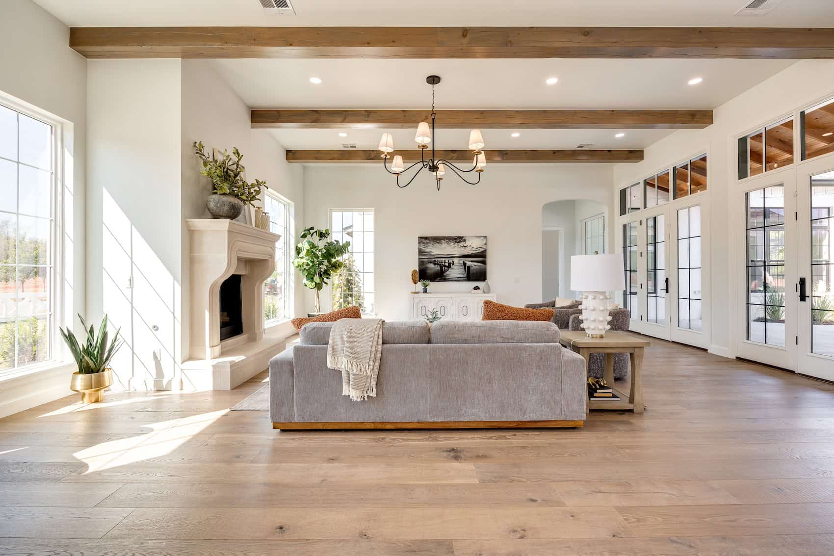 Warm, sunlit living room with textured wood flooring and soft finishes.