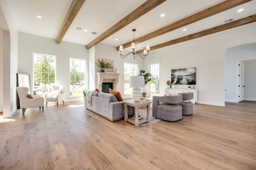 Bright living room with stone fireplace and wide-plank wood floors.
