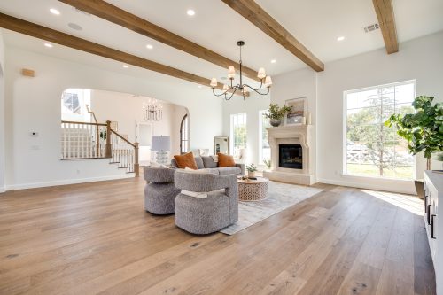 Bright living area with architectural beams and Real Wood Floors flooring.