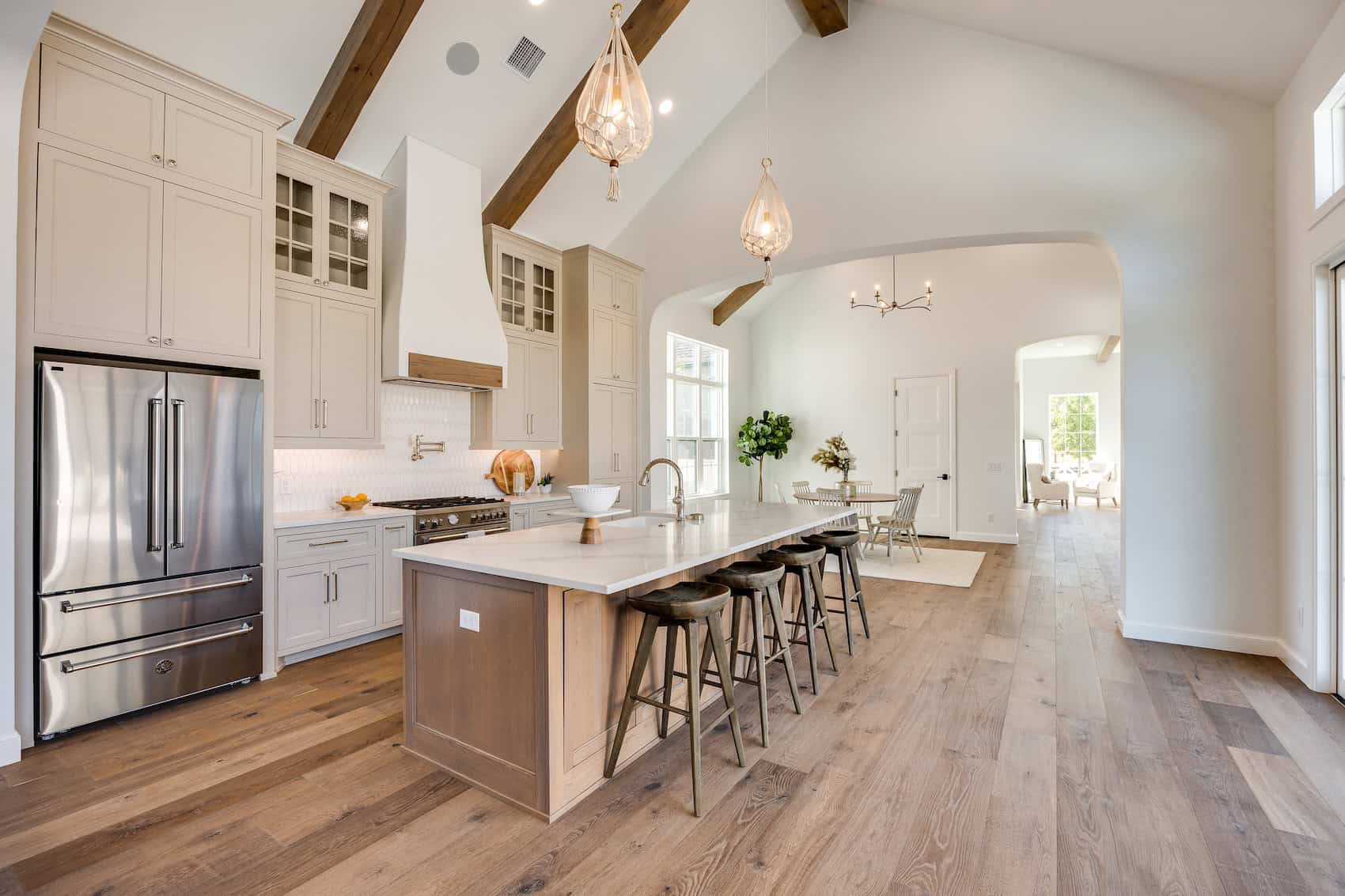 Bright and warm kitchen and dining area with cohesive hardwood flooring and neutral tones.