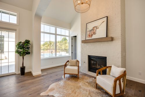 Seating area with armchairs, rug, and natural wood flooring.