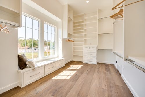 Bright closet with white shelving and european white oak hardwood flooring.
