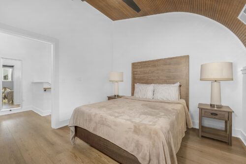 Upper-level bedroom with vaulted ceiling and neutral-toned rigid core flooring