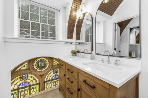 Bathroom vanity with quartz countertop and stained glass window detail