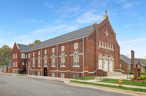 Historic church conversion in Wesley Heights with red brick exterior, arched windows, and original architectural detailing