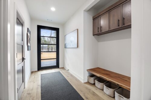 Lakefront cabin entryway with open layout and warm modern material palette