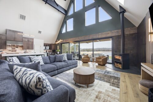 Open-concept A-frame living space with vertical wood detailing and wide plank flooring
