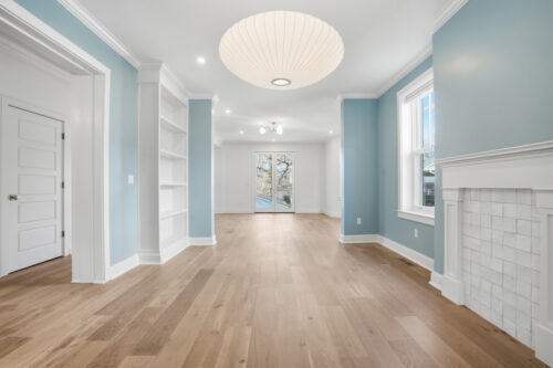 Living room with blue walls, ceiling medallion, and wide plank wood flooring