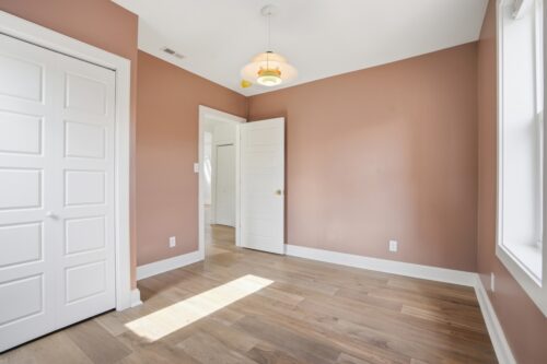 Sewickley home bedroom with warm flooring and painted walls