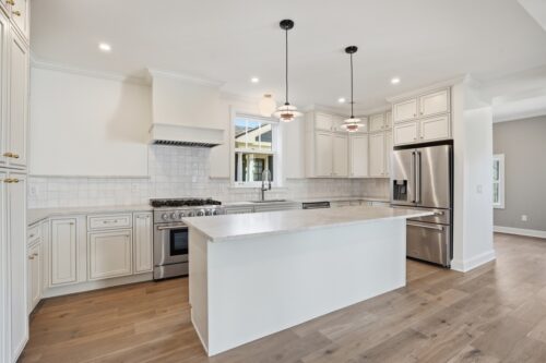 Wide view of kitchen with island and continuous Real Wood Floors