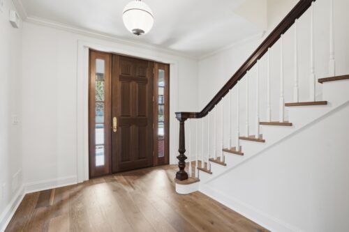 Traditional staircase with custom radius tread detail and natural wood flooring