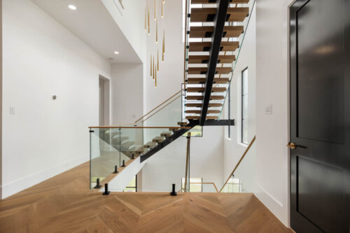 Custom wood staircase with integrated lighting in Riverstone Houston home