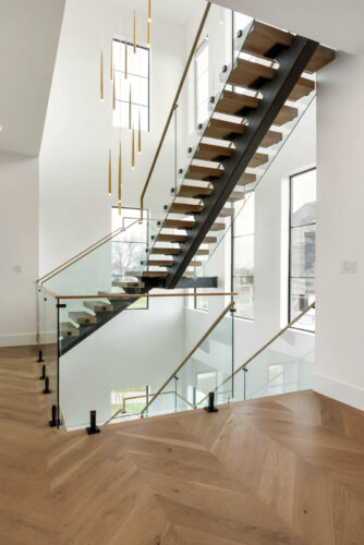 Houston-area lakefront home staircase with floating wood steps and built-in lighting