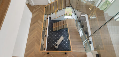 Three level wood staircase with custom Floormade treads and integrated lighting in Sugar Land TX