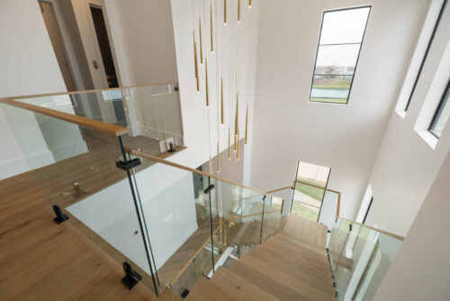 Custom Floormade staircase in Sugar Land TX with matching oak flooring and clean modern design