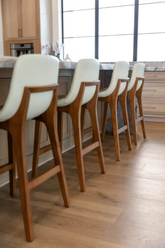 Houston-area kitchen with island, white stools, and Real Wood Floors