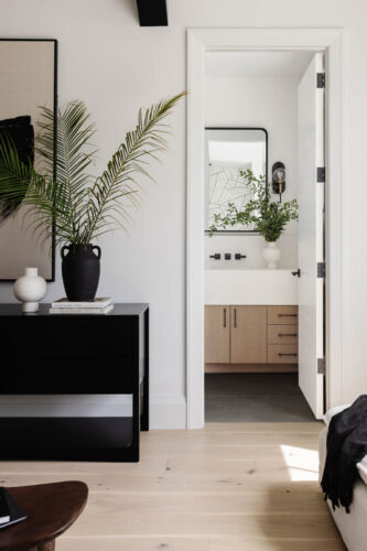 Organic coastal bedroom and office with light hardwood flooring and dark palette