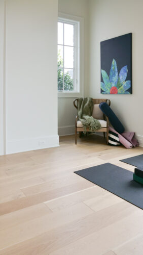 Cozy modern workout space featuring matte oak floors and natural light