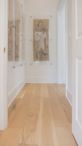 Modern corridor featuring original artwork and matte oak floors
