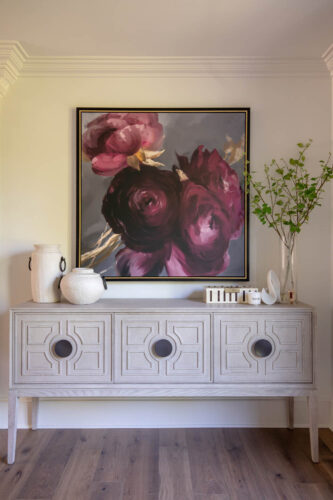Inviting entryway nook designed with warm white oak flooring and statement artwork.
