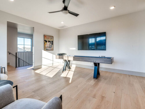 New construction game room with Battersea oak floors and a dedicated shuffleboard area