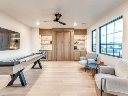 Wide light oak flooring creating continuity through a casual family game room