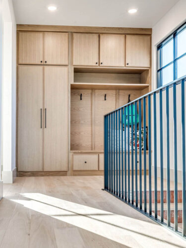 Light oak flooring beneath custom cabinetry in upper level