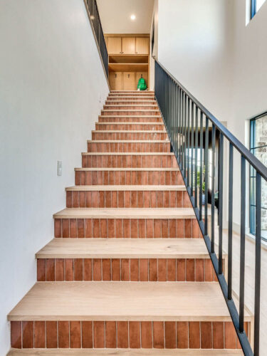 Custom staircase with Floormade wood treads, patterned tile risers, and Battersea oak flooring