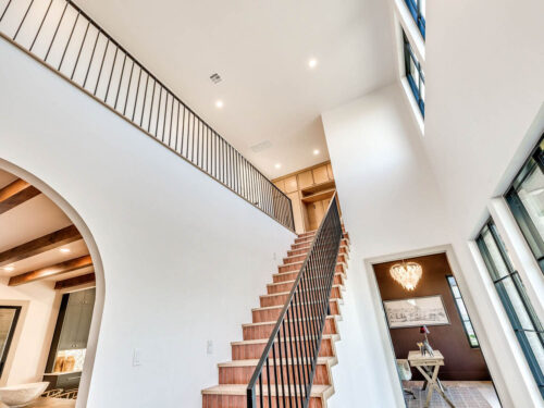 New build staircase featuring Floormade wood treads, patterned tile risers, and black metal railing