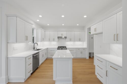 Retrospect Lily Pond flooring beneath white cabinetry and modern brass lighting