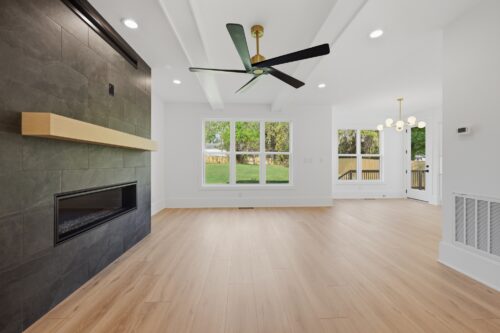 Modern living room with natural-toned flooring and a black tile fireplace